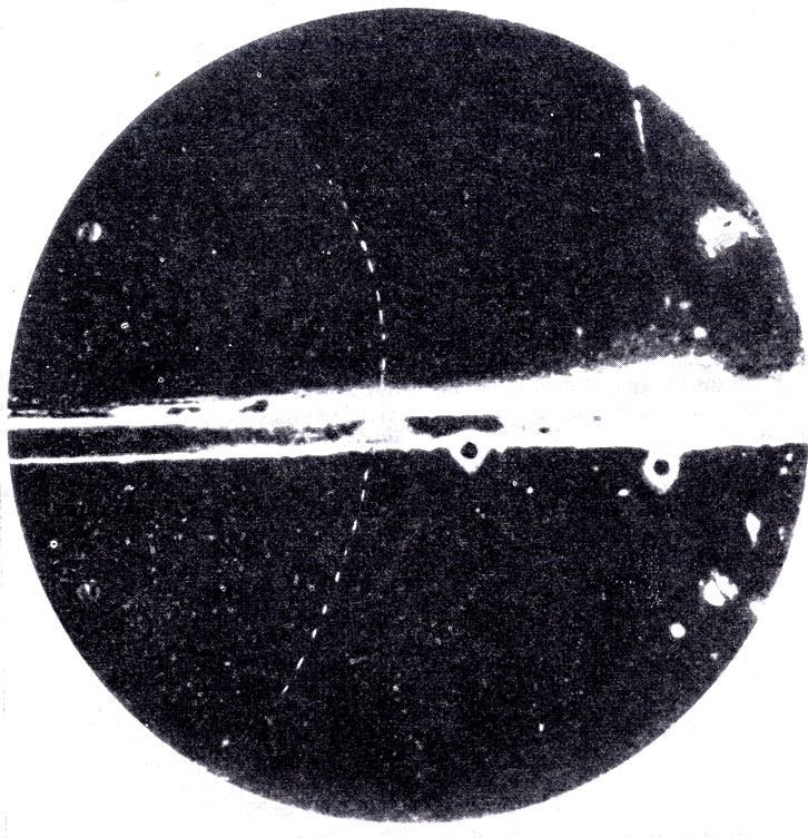 Первая фотография следа позитрона, полученная Андерсоном. (С. Anderson, The production and properties of positrons, Les Prix Nobel en 1936.) Энергия позитрона, пересекающего свинцовую пластинку (черная горизонтальная полоска), уменьшается от 63 миллионов эв до 23 миллионов эв, так что радиус кривизны его траектории уменьшается. Магнитное поле перпендикулярно плоскости фотографии
